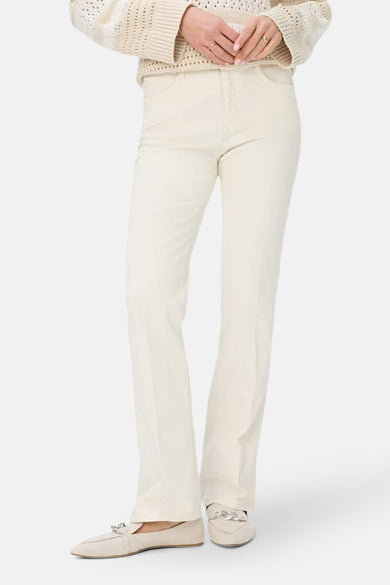 Jean bootcut en denim blanc cassé de BRAX, avec chaussures plates assorties et pull en tricot beige.

