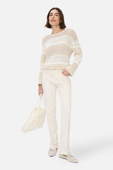 Jean bootcut blanc cassé en denim de BRAX, porté avec un pull rayé et des mocassins.
