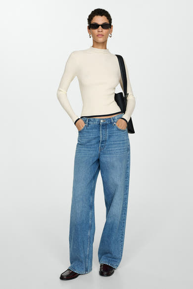 Witte trui met ronde hals van MANGO, gedragen met een wijde blauwe jeans en bordeauxrode loafers.