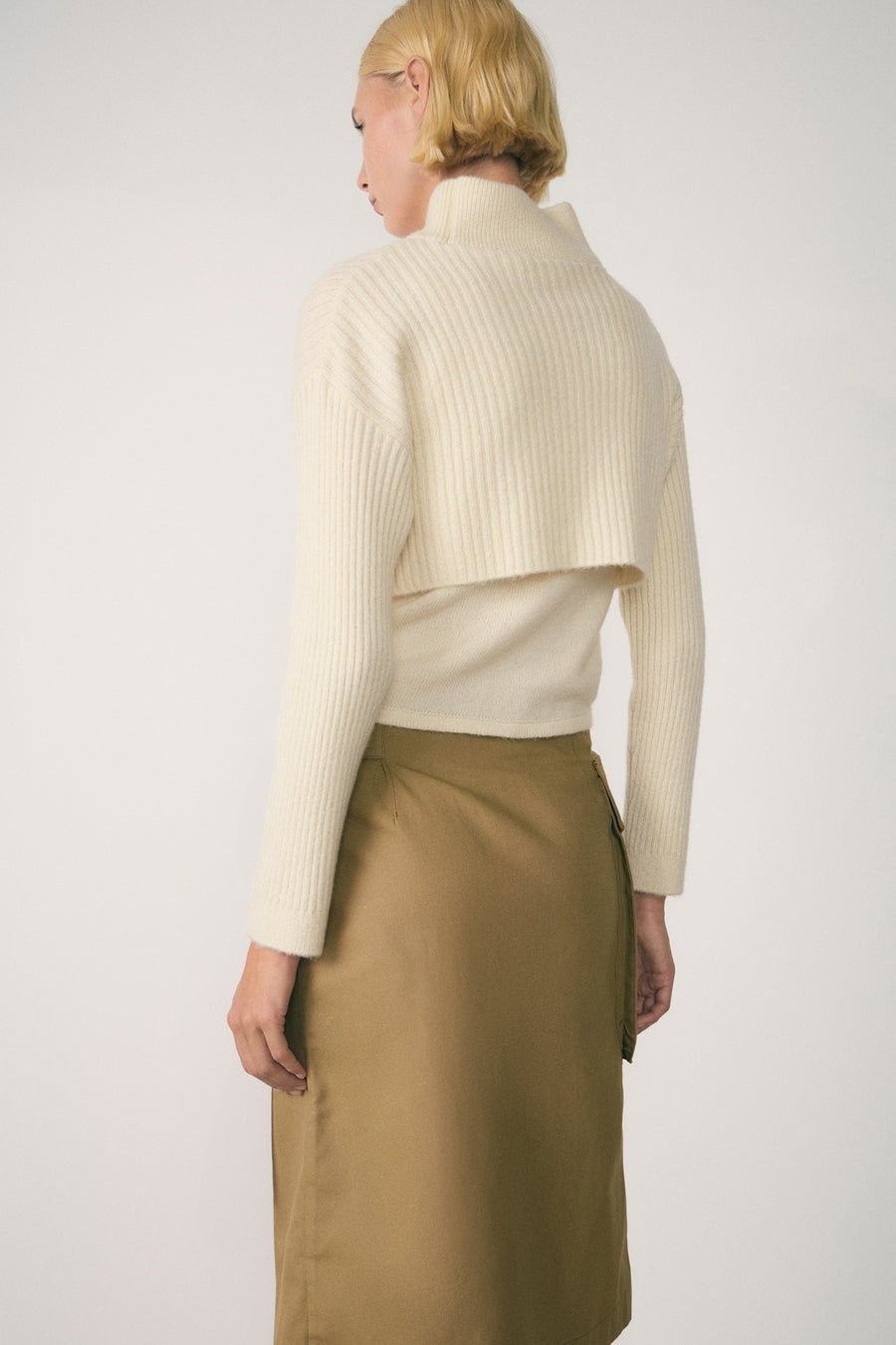 Witte coltrui van MANGO, korte pasvorm met ribgebreide stof, gedragen met een bruine rok.