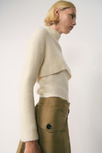 Witte coltrui van MANGO, gedragen met een bruine top en rok, zijaanzicht.