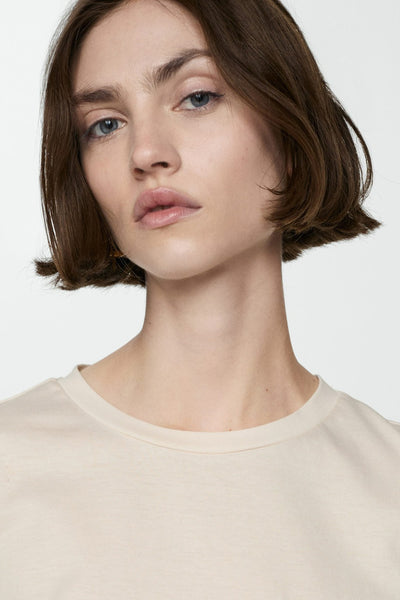 Beige T-shirt met korte mouwen van MANGO, gedragen door een model, klassieke pasvorm met ronde hals.
