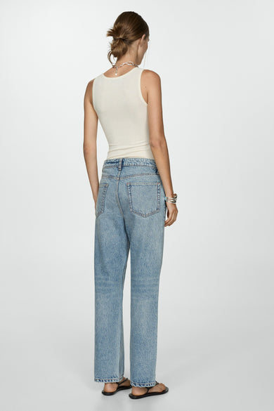 Jean en denim bleu clair de MANGO, coupe droite avec détail de bracelet argenté et sandales noires.
