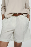 Ecru short van MANGO, gestreept, gedragen met een beige top met lange mouwen en sandalen met bandjes.