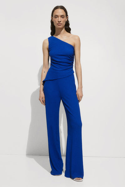 Top bleu sans manches de MANGO, avec un design asymétrique et drapé sur le devant.