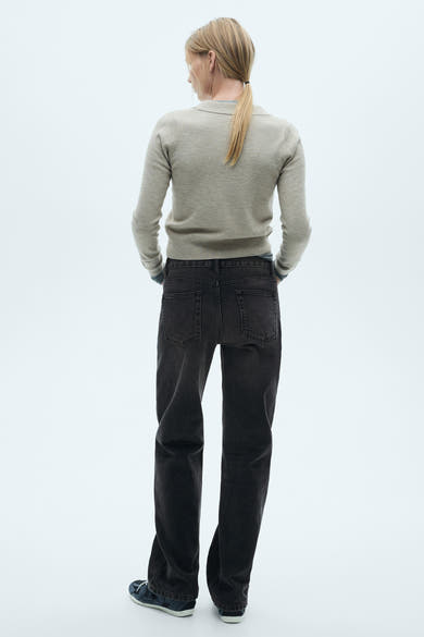 Donkergrijze rechte jeans van MANGO, gedragen met een beige trui, achtergezicht.