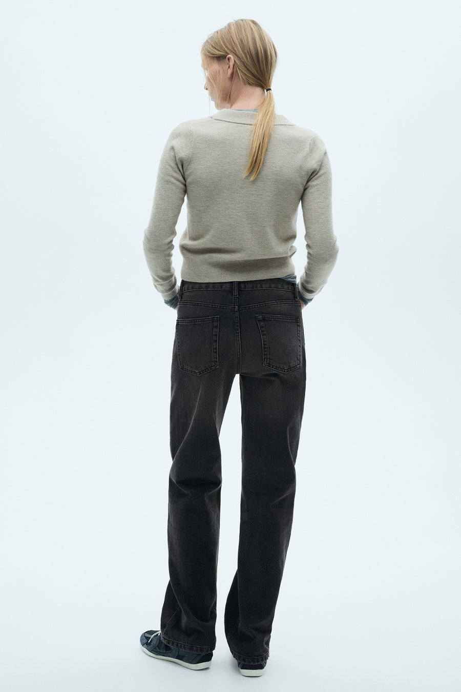 Donkergrijze rechte jeans van MANGO, gedragen met een beige trui, achtergezicht.