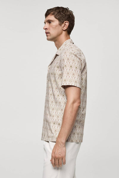 Beige overhemd met korte mouwen van MANGO, met ruitpatroon, gedragen met een witte broek.