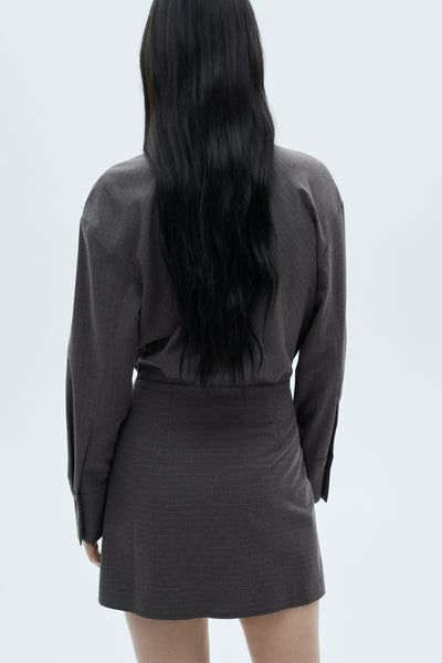 Robe grise à manches longues de MANGO, avec une coupe courte et un tissu texturé.