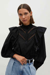 Blouse noire à manches longues de MANGO, avec dentelle aux épaules et aux manches bouffantes.