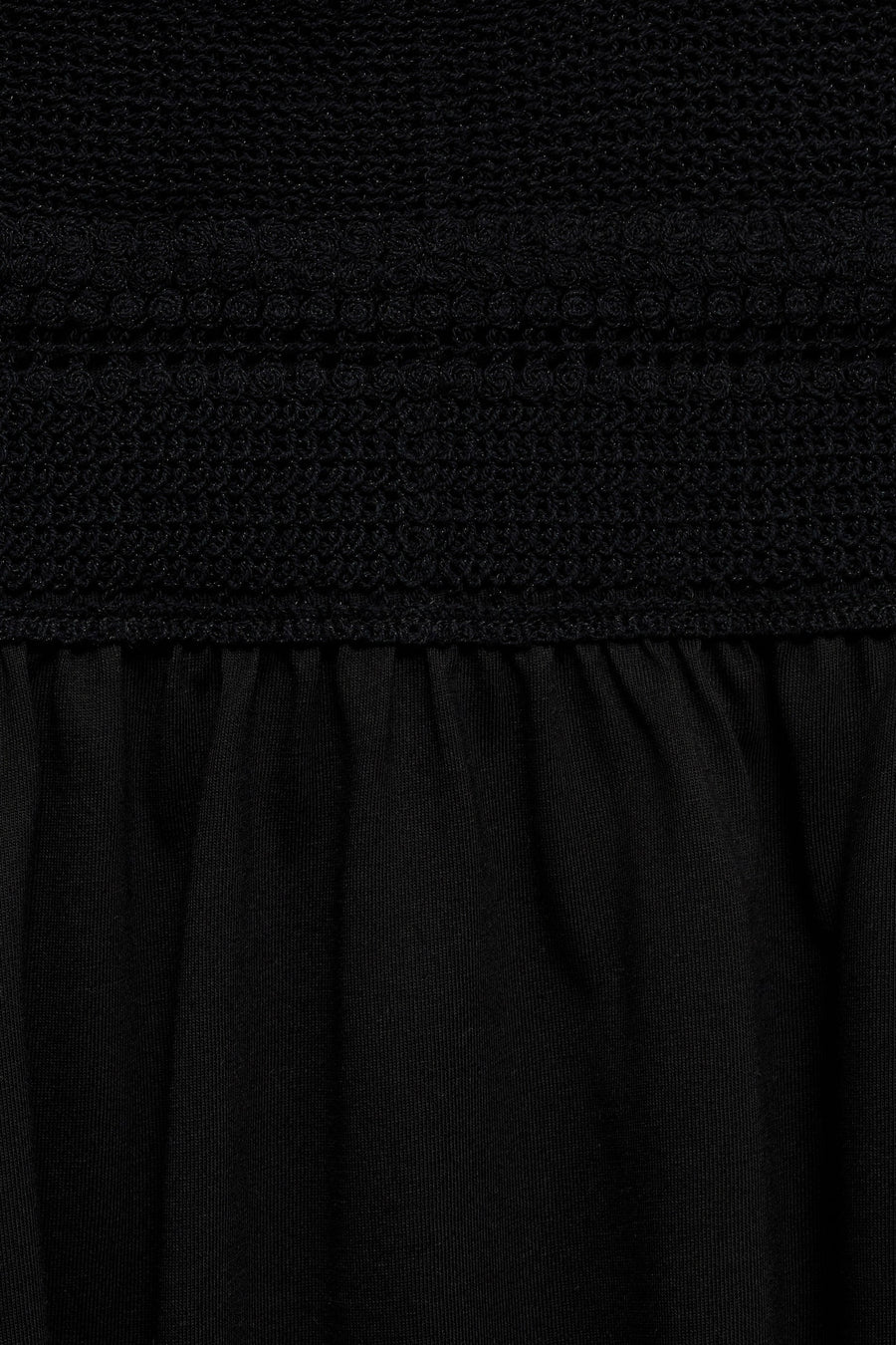 Zwarte jurk van MANGO, met ingewikkelde haakdetails en een geplooide textuur onder de tailleband.