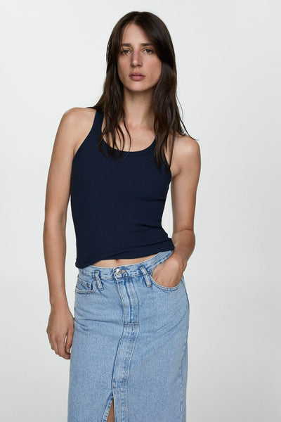 Mid blue denim skirt with front slit and classic five-pocket design, worn with navy ribbed tank top, full-length lifestyle view