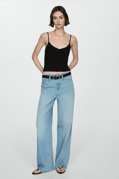 Zwarte top met dunne bandjes van MANGO, gedragen met een high-waisted jeans en een zwarte riem.