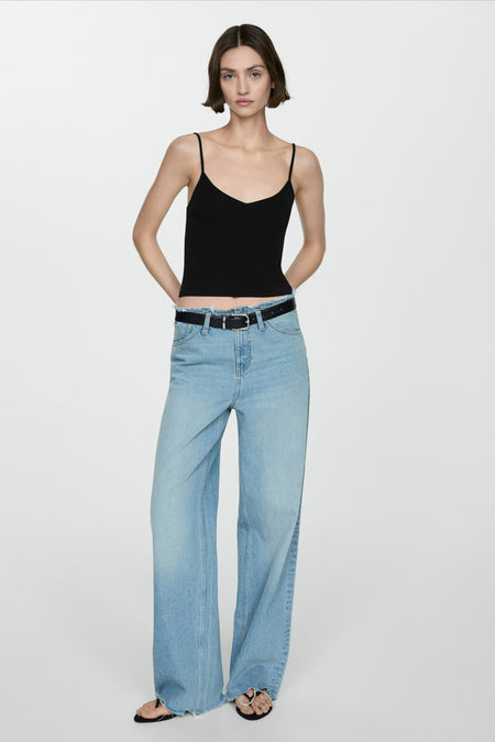 Zwarte top met dunne bandjes van MANGO, gedragen met een high-waisted jeans en een zwarte riem.
