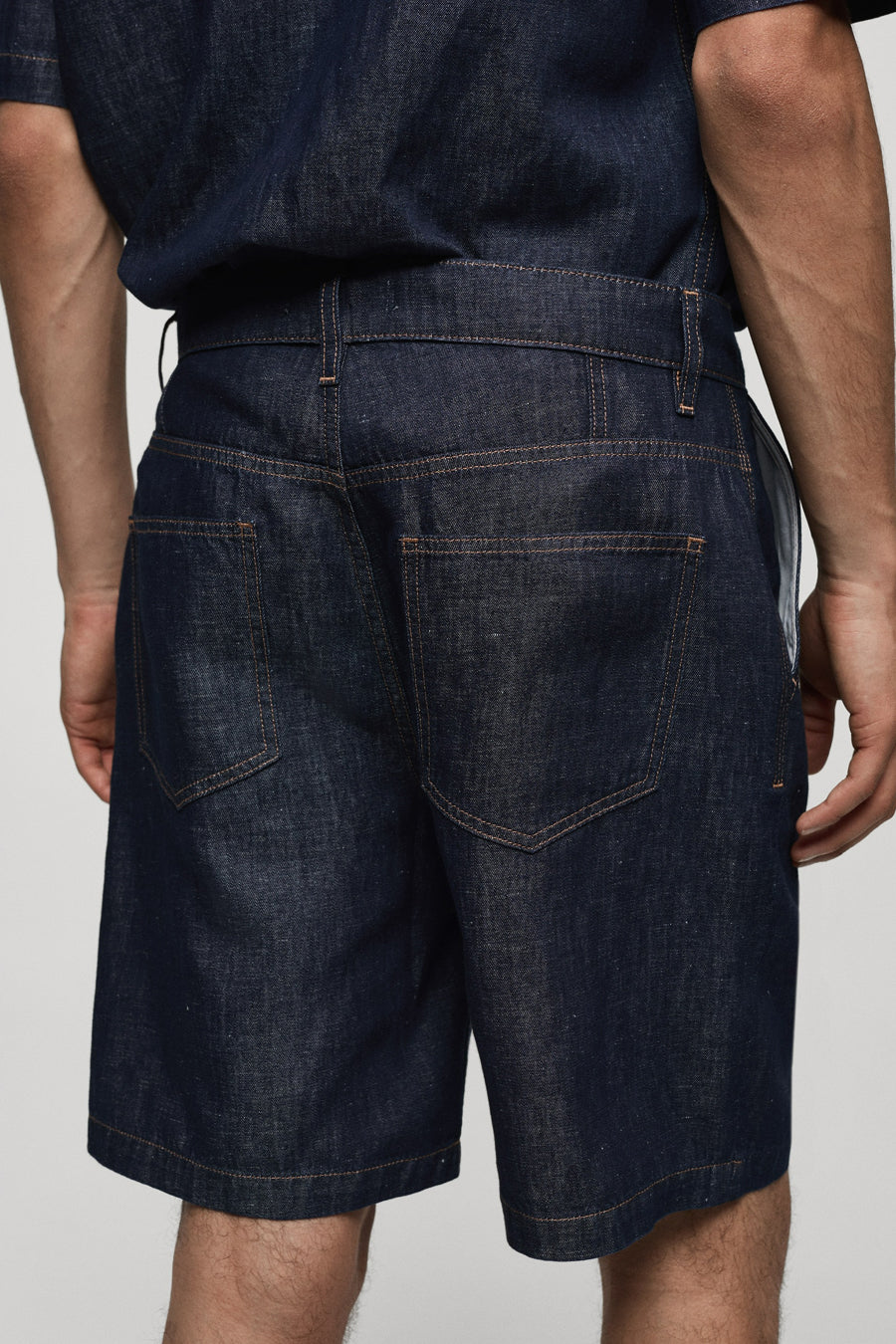Short en denim bleu moyen de MANGO, avec des poches arrière carrées et une coupe mi-cuisse.