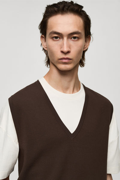 Bruin hemdje van MANGO, gedragen over een wit T-shirt met ronde hals, voor een neutrale achtergrond.