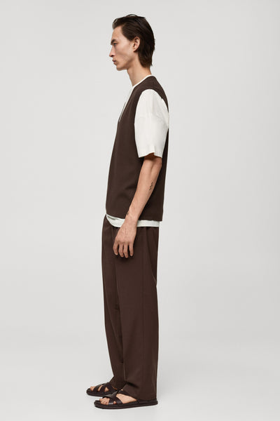 Bruin hemdje van MANGO, gedragen over een wit T-shirt, met een bijpassende broek en sandalen.