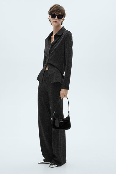 Gemêleerde grijze broek van MANGO, wijde en rechte pasvorm, gedragen met een bijpassend hemdje, zilveren schoenen en een zwarte tas.