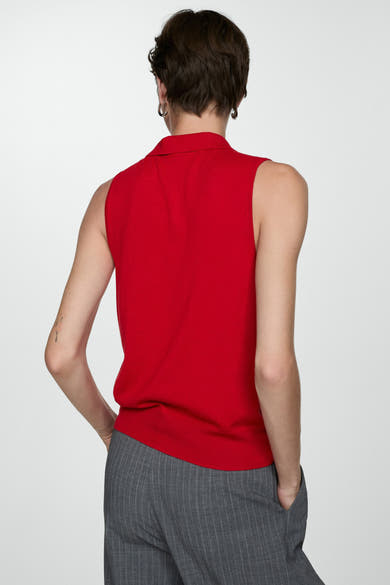 Rode MANGO polo, mouwloos, gedragen met een gestreepte broek, achterzicht.