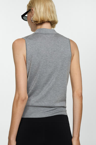 Polo brun van MANGO, sans manches, porté avec un pantalon noir taille haute, vue de dos.