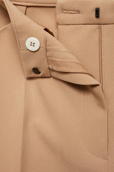 Beige broek van MANGO, met zichtbare ritssluiting en witte knoop.