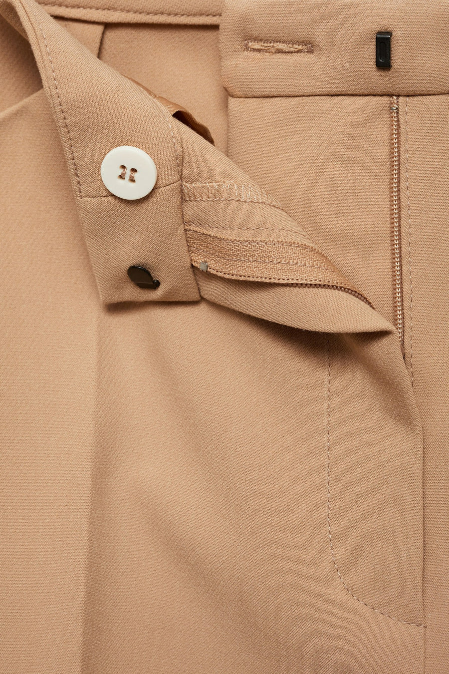 Beige broek van MANGO, met zichtbare ritssluiting en witte knoop.