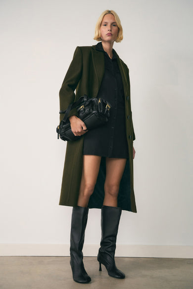 Robe à manches longues multicolore de MANGO, portée avec un manteau olive et des bottes noires.
