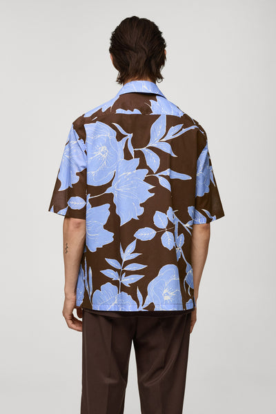 Chemise marron à fleurs bleues de MANGO, vue de dos, portée avec un pantalon assorti.