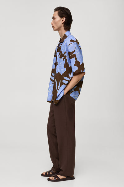 Bruin bedrukt overhemd met korte mouwen, van MANGO, met blauw bloemenpatroon en bruine broek.