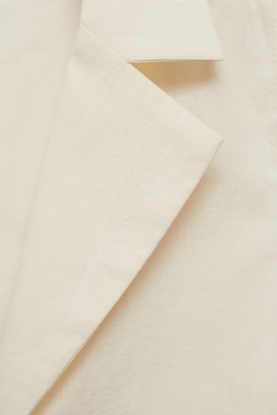 Chemisier beige sans manches de MANGO avec texture en lin et col tailleur.