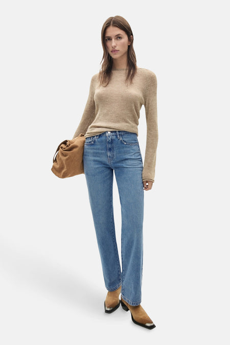 Middelblauwe rechte jeans van MANGO, gedragen met een beige trui en bruine suède enkellaarsjes.