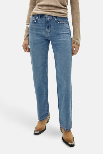 Rechte blauwe denim jeans van MANGO, gedragen met een lichtbruine trui en suède puntlaarzen.