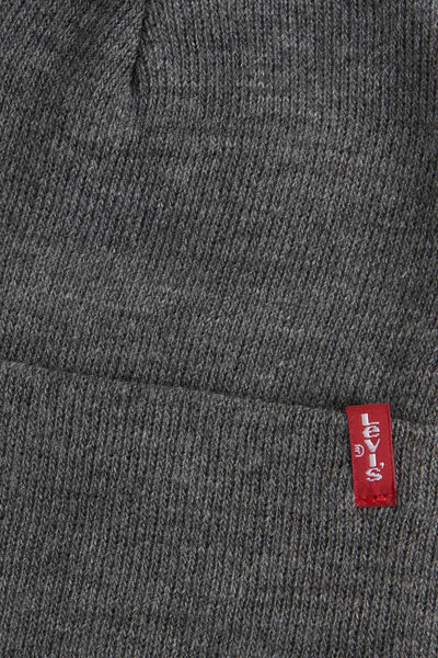 Bonnet gris en maille par Levi's® Accessories, avec un logo rouge cousu sur le bord inférieur.