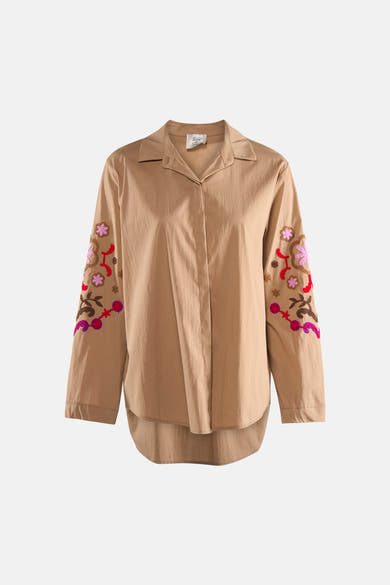Chemise beige à manches longues de Terra di Siena, avec des broderies florales sur les manches.
