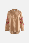 Chemise beige à manches longues de Terra di Siena, avec des broderies florales sur les manches.
