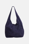 Navy blue suede shoulder bag with slouchy design and long strap, front view