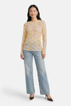 T-shirt jaune à manches longues de Terra di Siena, à motif floral, porté avec un jean et des escarpins marron.
