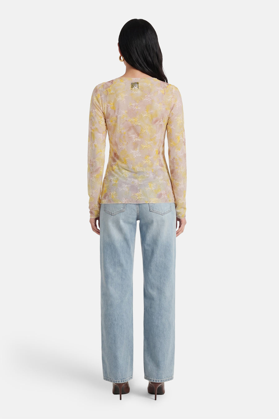 T-shirt jaune à manches longues de Terra di Siena, imprimé floral délicat, porté avec un jean taille haute.
