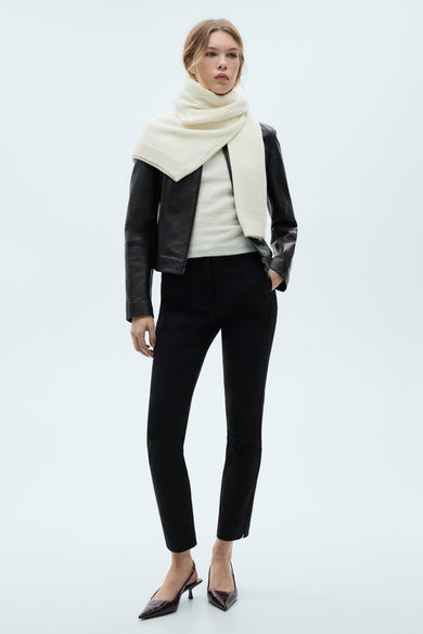 Zwarte broek van MANGO, gedragen met een lederen jas, een trui en een donkere sjaal, en bruine escarpins met spitsen.