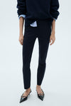 Donkerblauwe broek van MANGO, slim fit, gedragen met een gebreide trui en naaldhakken.