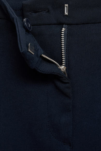 Donkerblauwe broek van MANGO, met zichtbare zilveren ritssluiting en zichtbare knoop.