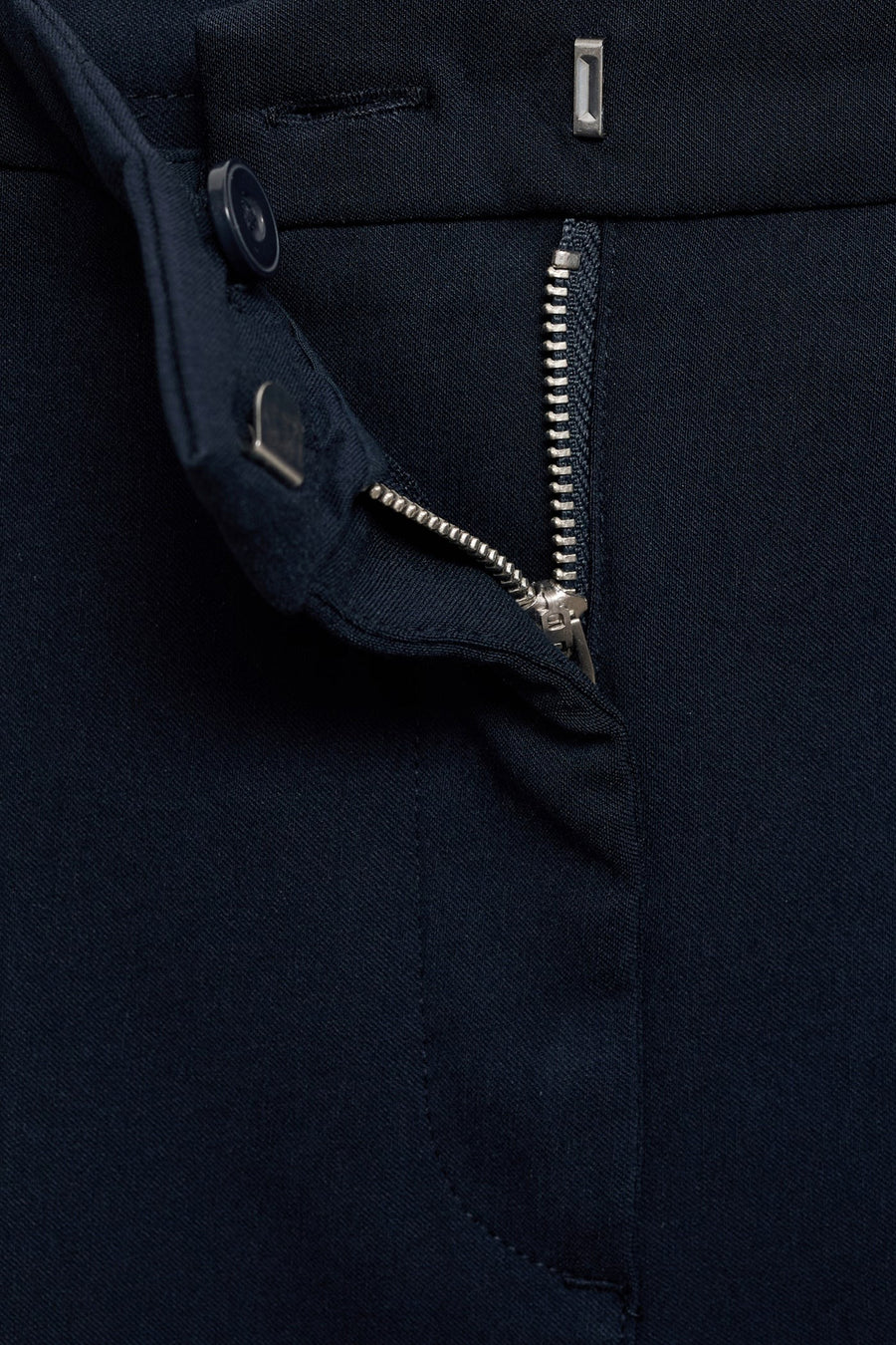 Donkerblauwe broek van MANGO, met zichtbare zilveren ritssluiting en zichtbare knoop.