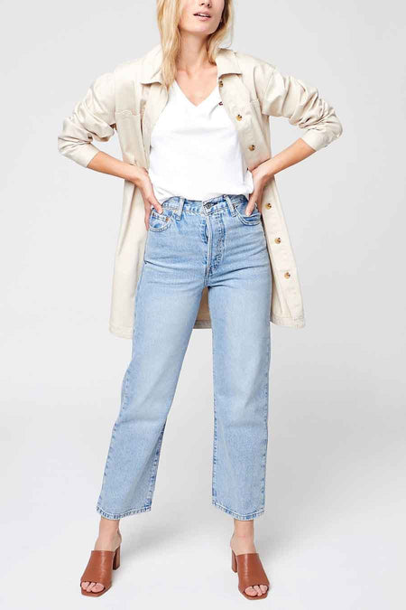 Top blanc de Levi's, porté avec une chemise beige ouverte et un jean taille haute bleu clair.