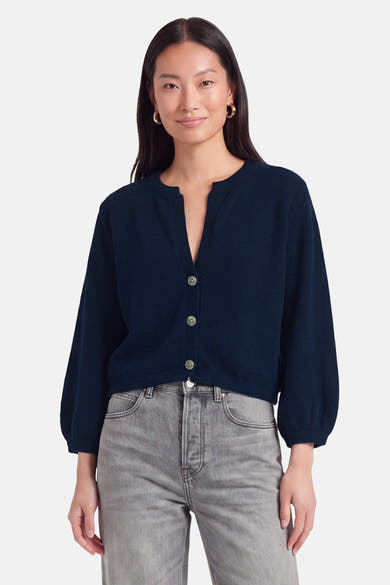 Gilet bleu marine en maille fine par Terra di Siena, boutonné avec manches ballon, porté avec jeans gris clair