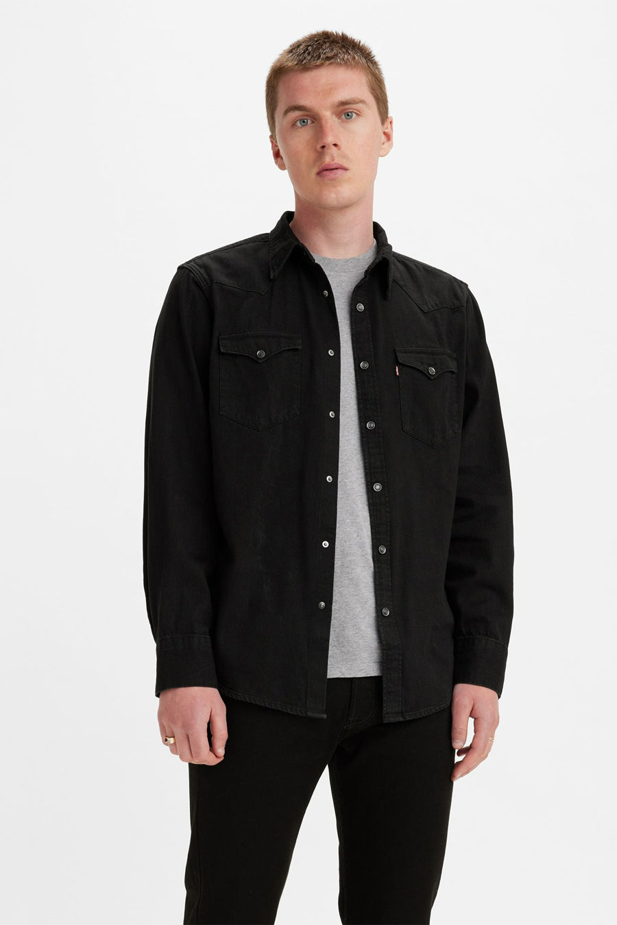 Chemise noire à manches longues de Levi's, portée ouverte sur un t-shirt gris, avec des poches à rabat.
