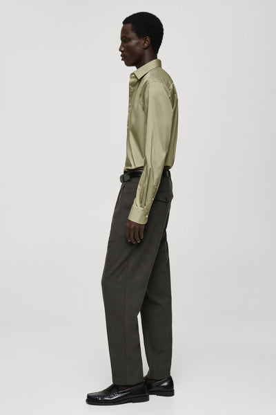 Chemise kaki à manches longues de MANGO, portée avec un pantalon gris et des chaussures noires.