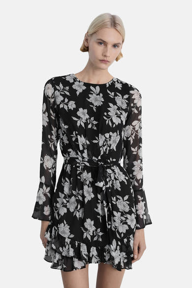 Multikleurige bloemenjurk van MANGO, met een strikceintuur, lange mouwen en een volantzoom.
