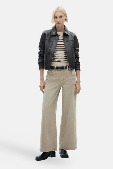 Ronde mouwige beige van MANGO, met horizontale zwarte strepen, gedragen met een zwarte lederen jas en een breed begeel pantalon.