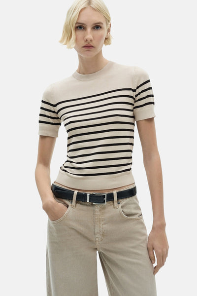 Rondewulenige beige-shirt van MANGO, met horizontale zwarte strepen, gedragen met een beige-pantalon en een zwarte riem.