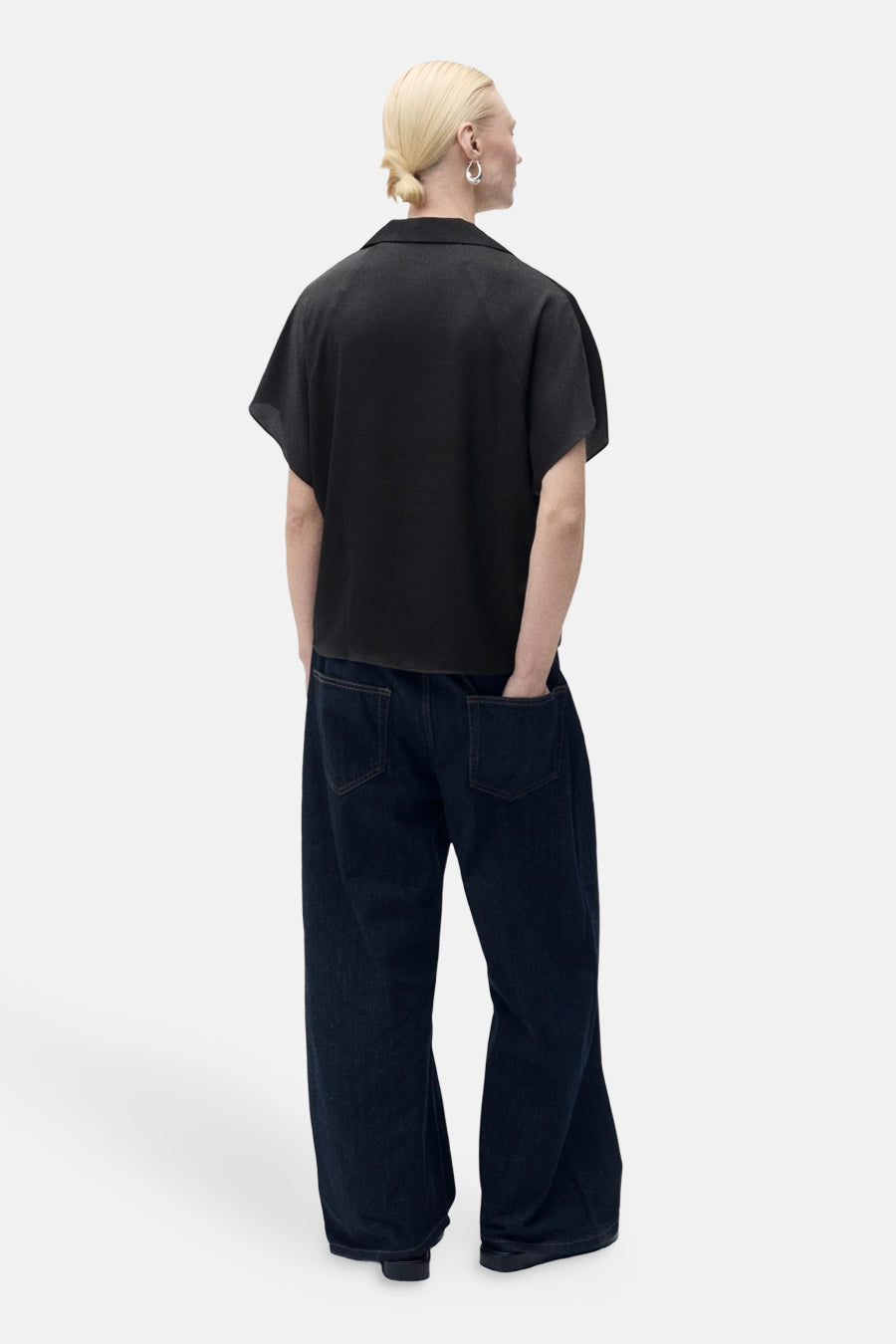 Chemise noire à manches courtes de MANGO, portée avec un jean large indigo, vue de dos.